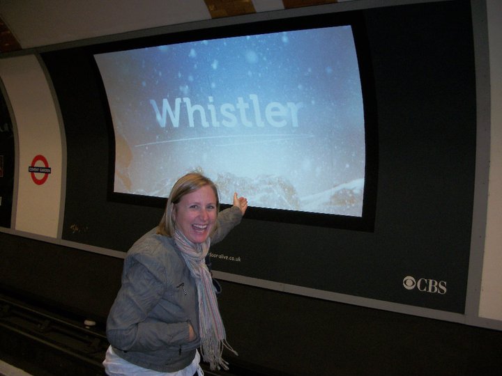 Shawna Lang points at a Tourism Whistler ad in the London Underground.