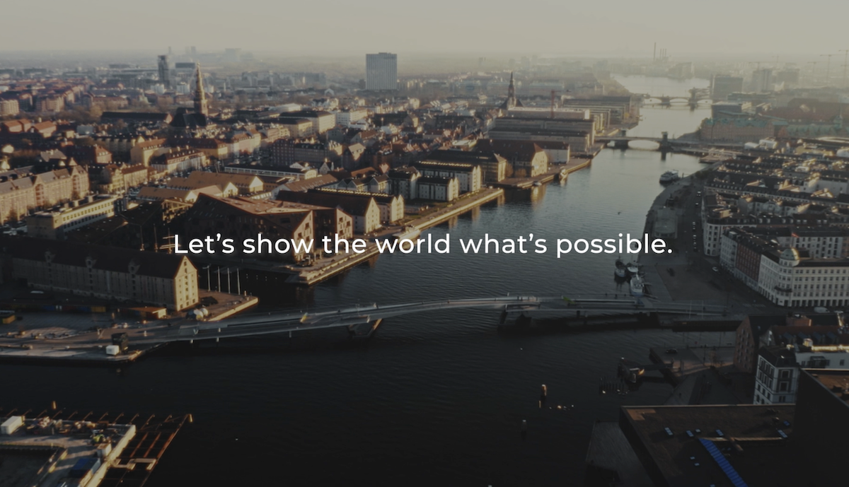 A river flowing through a city with overlay text, "Let's show the world what's possible"