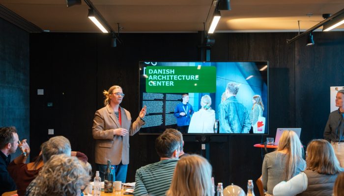 A woman from the Danish Architecture Centre speaks to attendees.
