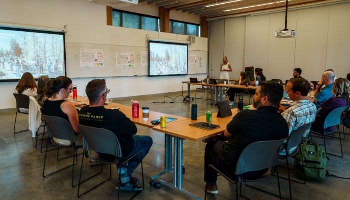 Workshop participants sit around a U-shaped table.