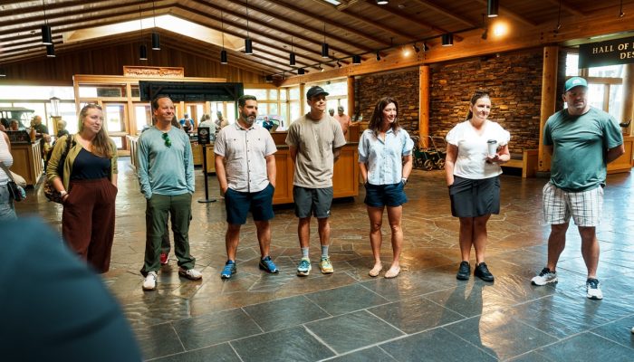 People stand in a semi-circle in the lobby of a museum.